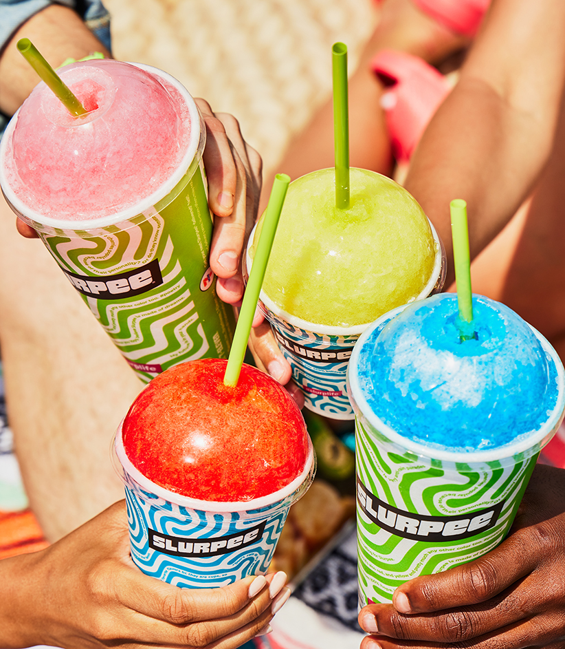 Close up of a diverse group toasting 7-Eleven Slurpee drinks on a sunny day