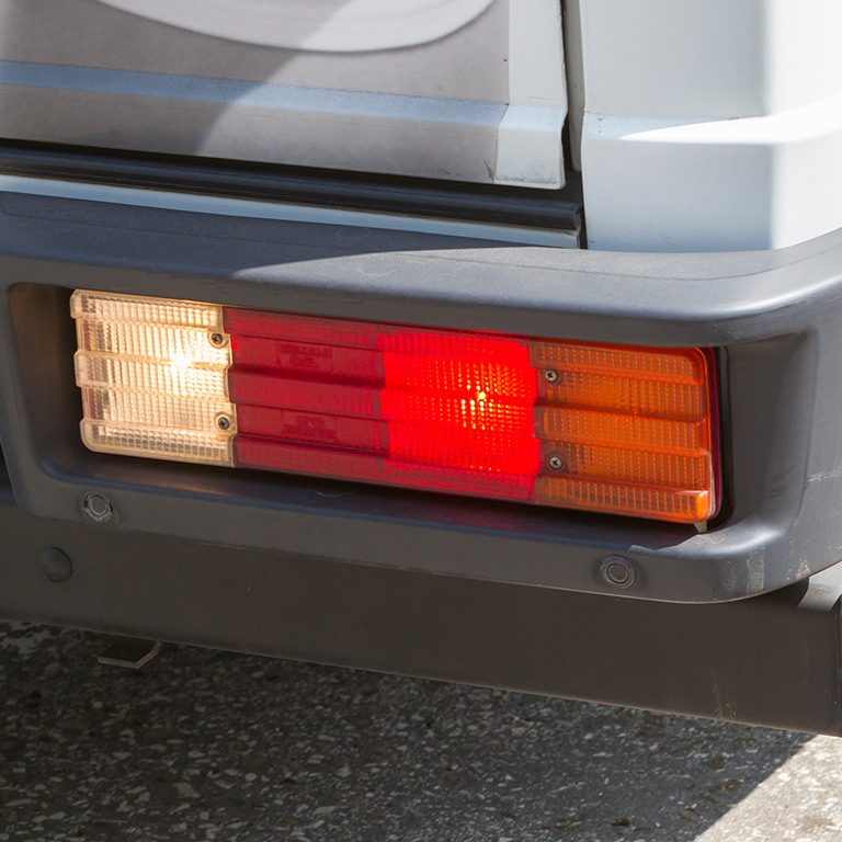 Close-up of a vehicle's rear lights, highlighting the importance of visibility and safety during low-speed manoeuvres to mitigate risks in fleet operations.
