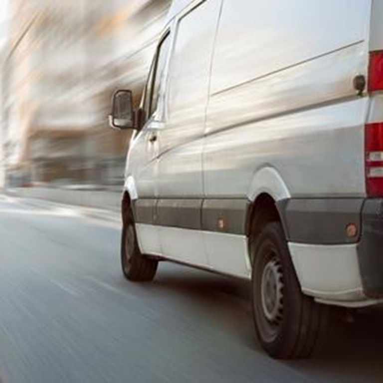 Van driving fast on road with surroundings blurred