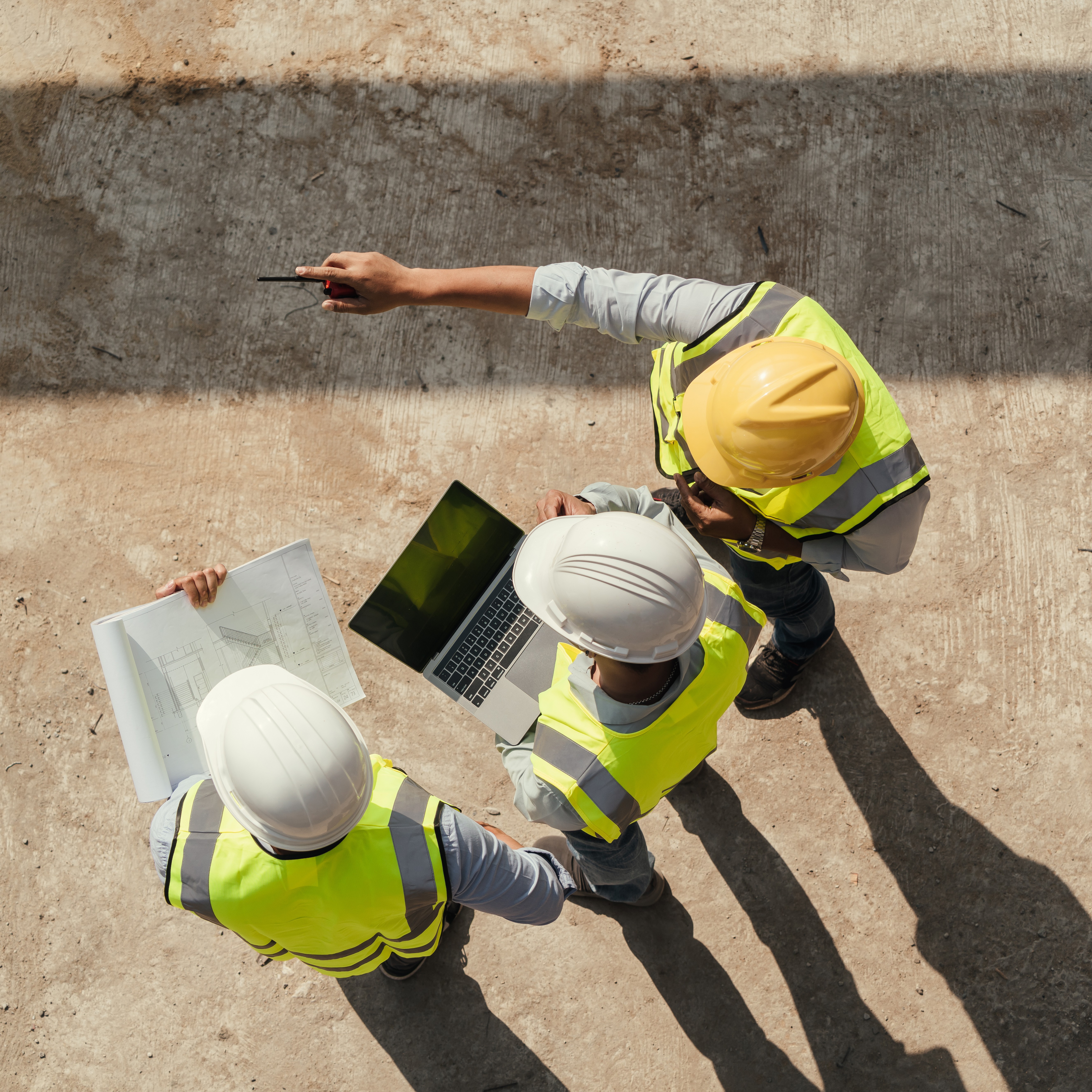 Top view, Team engineer building inspection use tablet computer and blueprint working at construction site.