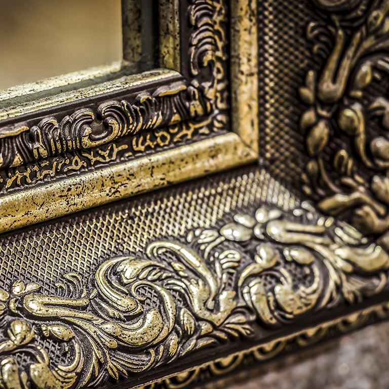 Part of the ornate, carved mirror frame in ancient style.
