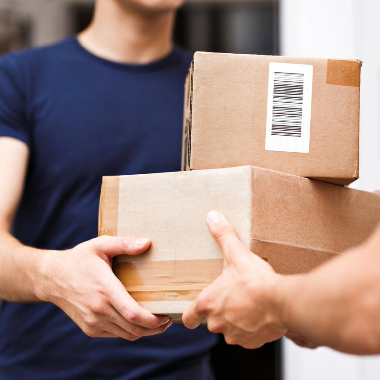 Close-up of boxes being delivered from one person to another.